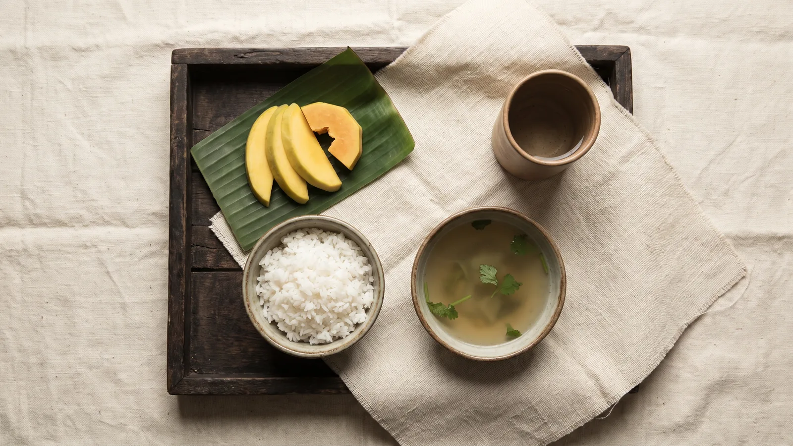 Mâm cơm chay đơn sơ nhìn từ trên xuống trên khay gỗ và vải thô — minh họa quán tưởng khi thọ thực